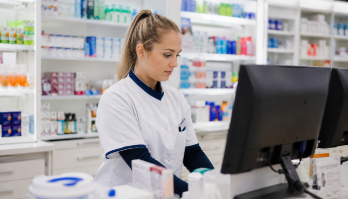 Apotheekassistent in de apotheek achter een computerscherm